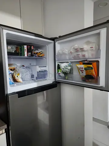 Used top-freezer refrigerator in good working condition - stainless steel