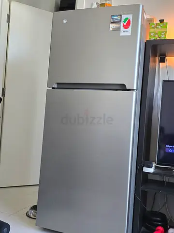 Silver double-door refrigerator in good condition (top freezer)