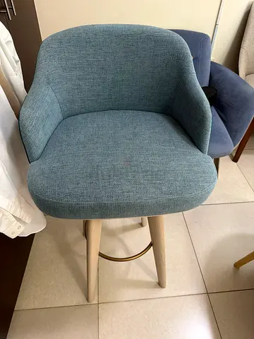 Light blue upholstered bar chair with wooden legs