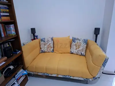 Compact yellow 2-seater sofa with floral base - good condition