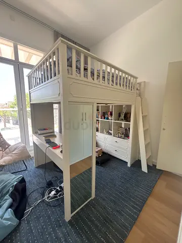 White wooden loft bed with storage shelves and desk