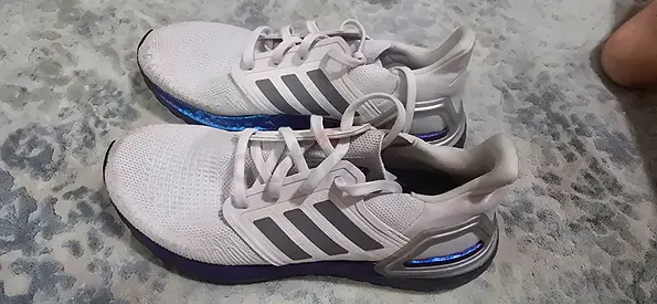 White Adidas running shoes with grey stripes, lightly used