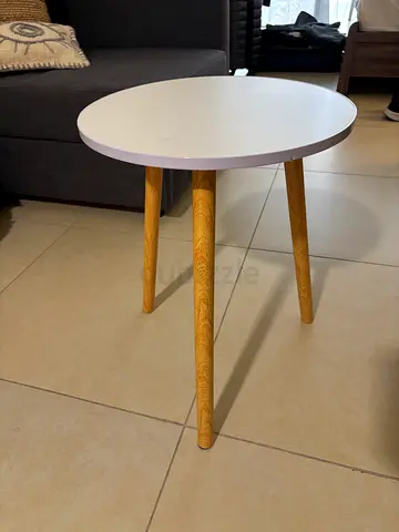 Small round side table with white top and wooden legs