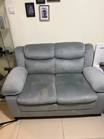 Two-seater grey leather sofa in good used condition