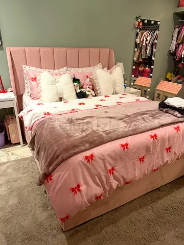 Pink upholstered queen bed frame with padded headboard