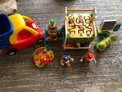 Bundle of mixed toddlers toys: walker cube, ride-on car, stacking rings, interactive toys