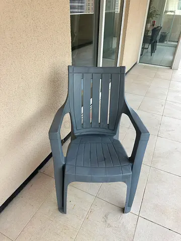 Used grey plastic outdoor chair - sturdy and stackable