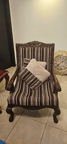Antique-style carved wooden armchair with striped upholstery