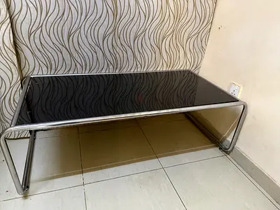 Minimalist black glass coffee table with chrome frame