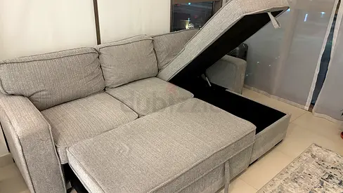 Light grey fabric L-shaped storage sofa bed — perfect condition for quick sell.