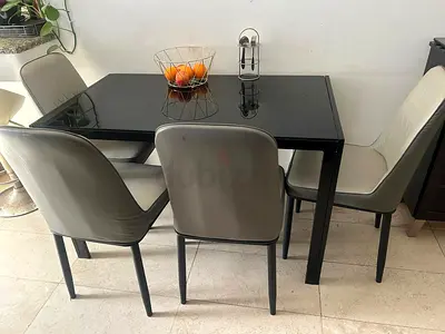 Black glass-top dining table with 4 grey chairs - good condition