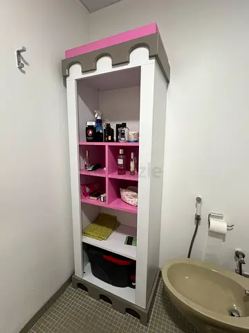 Tall bathroom storage cabinet with open shelves (white, pink accents)