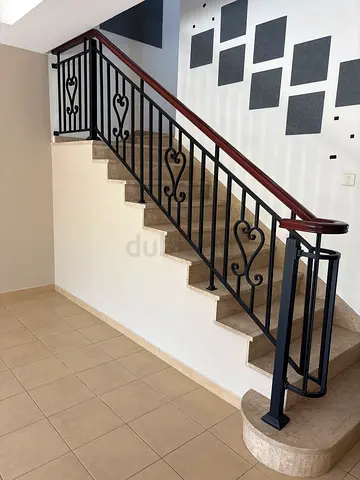 Wrought iron staircase railing with wooden handrail - good condition