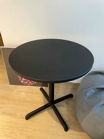Small round black side table with cross base