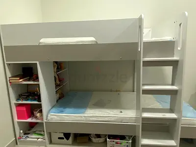 White wooden bunk bed with built-in shelves and ladder with mattresses