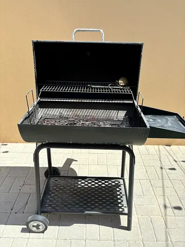 Used charcoal grill with side shelf and lid - good condition