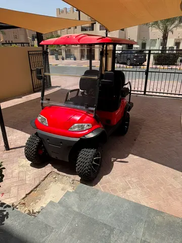 Red electric golf cart with all terrain tires