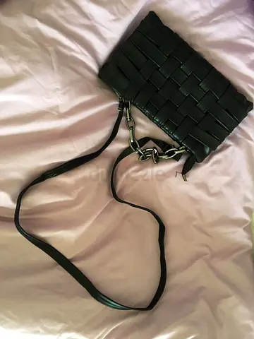 Black woven leather crossbody bag with chain detail
