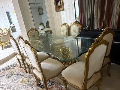 Classic Gold-Framed Glass Dining Table with 8 Upholstered Chairs with a luxury gold storage shelf