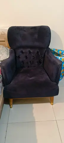 Single navy velvet armchair with button-tufted back and brass legs