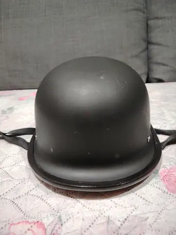 Used matte black protective helmet (size unclear) — good condition