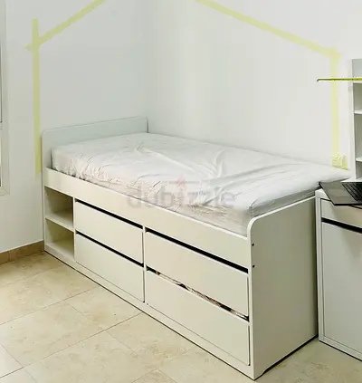 White single bed with built-in drawers and shelving from IKEA