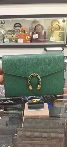 Green leather shoulder bag with tiger head closure