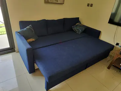 Blue fabric pull-out sofa bed with storage - good condition