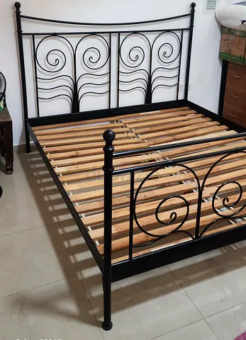 Metal double bed frame with decorative headboard and wooden slats