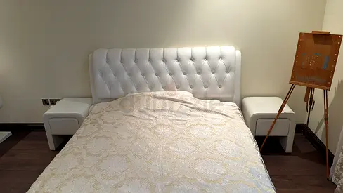 White tufted queen-size bed with two matching bedside tables, mattress included