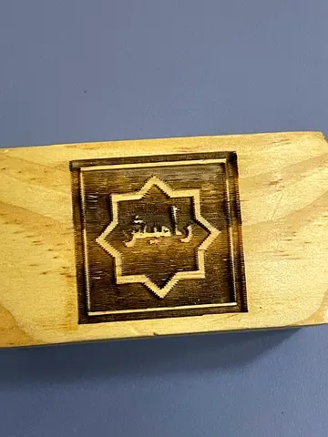 Hand-carved wooden stamp with Arabic motif