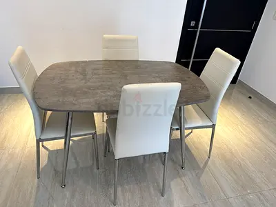 4-seat dining table with grey stone-look top and white chairs