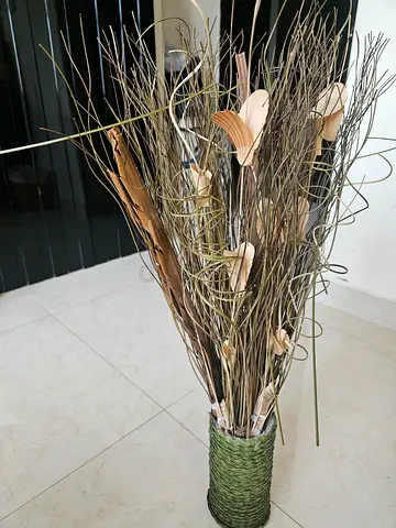 Tall decorative dried twig floor arrangement in woven vase