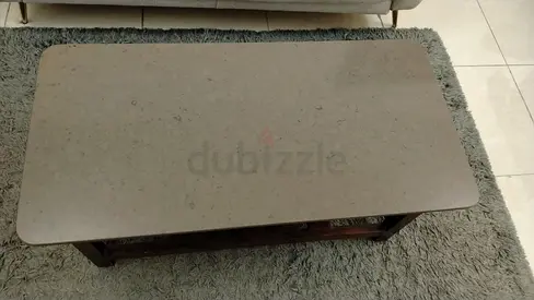Wooden coffee table with stone-look top on grey $%! rug