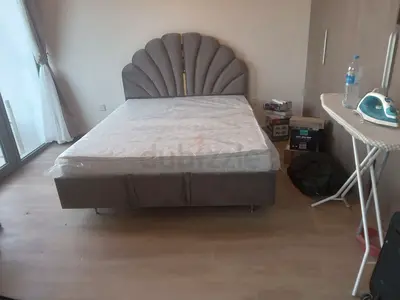 Queen upholstered bed with shell-style headboard — good condition