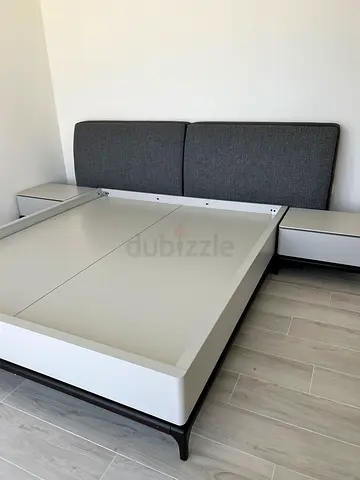 Modern white platform bed with grey upholstered headboard and side tables