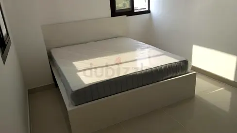 IKEA-style white platform double bed frame with mattress