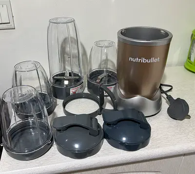 NutriBullet blender set with multiple cups and lids - Excellent condition