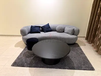 Modern curved 3-seater sofa with coffee table and rug - good condition