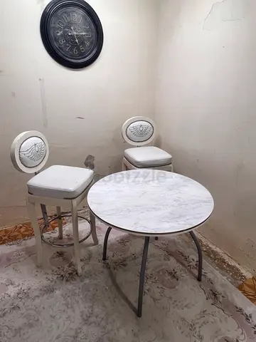 Small round marble-top dining table with two stools — compact set