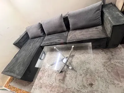L-shaped grey velvet sofa set with glass coffee table
