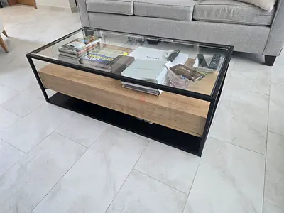 Modern glass-top coffee table with wooden drawer
