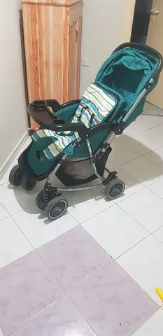 Lightly used teal single stroller with storage basket and canopy