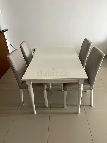 White wooden dining table with 4 upholstered chairs