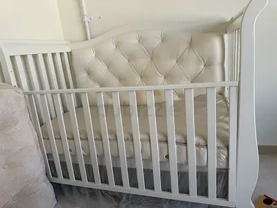 White wooden baby crib with padded headboard - gently used