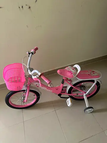 Pink kids bicycle with training wheels and front basket - good condition