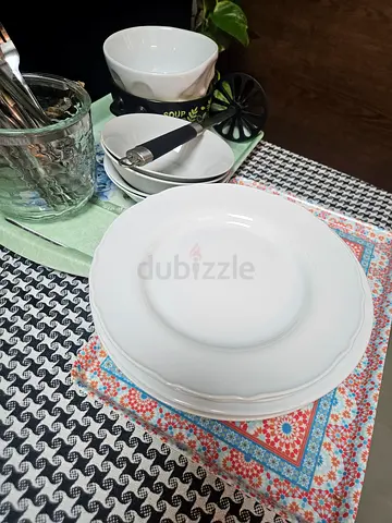Dinnerware set: white plates and bowls with cutlery and serving pieces