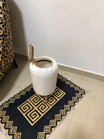 Modern white plastic trash can with legs
