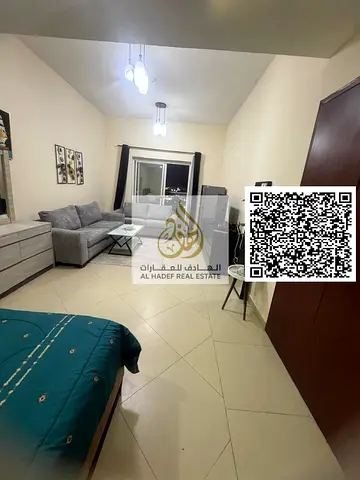 Furnished studio apartment in Al Nuaimiya 1, Al Shurooq Towers. Features a semi-separate kitchen and balcony, high-end furnishings, and a spacious lay