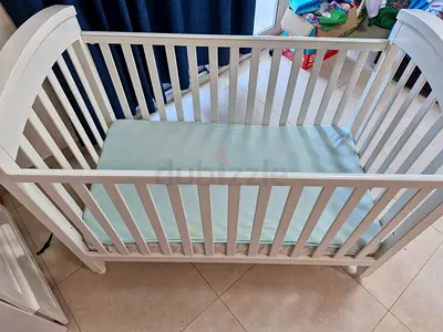 Crib with mattress kept inside waterproof mattress cover